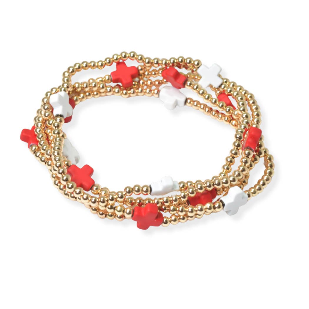 Set of gold beaded bracelets with red and white star-shaped beads on a white background