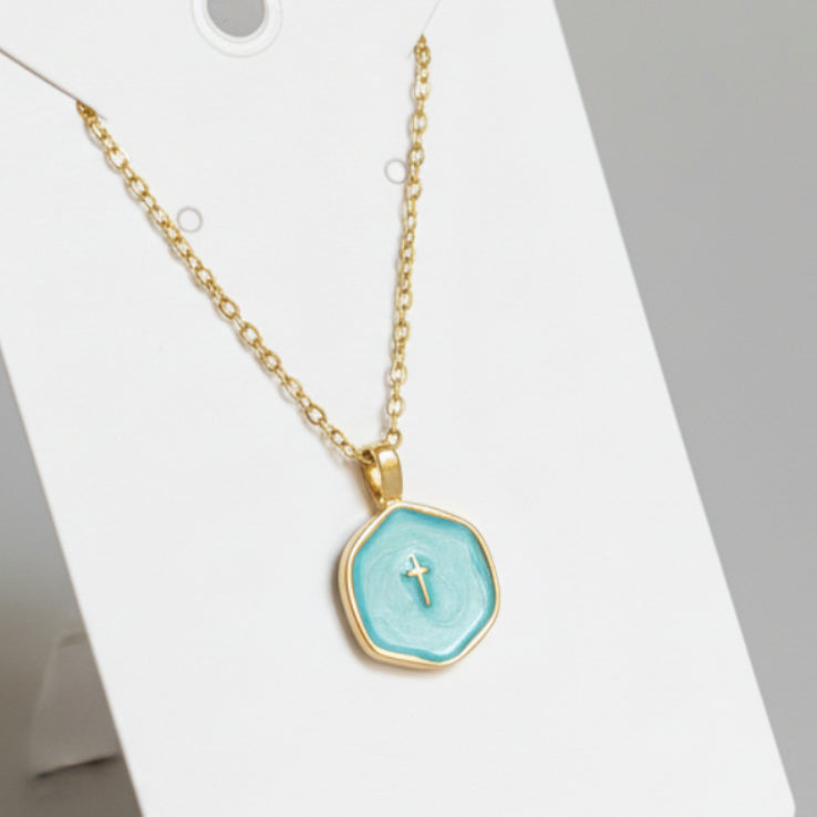 Gold necklace with a turquoise pendant on a white background