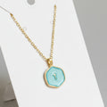 Gold necklace with a turquoise pendant on a white background